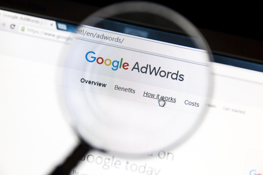 An image of Google AdWords page, focused by a magnifying glass to represent Kazzicoms focus on Google Adwords