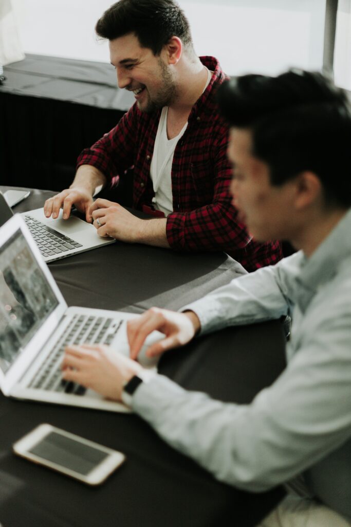 2 people working on laptops representing the Kazzicom team