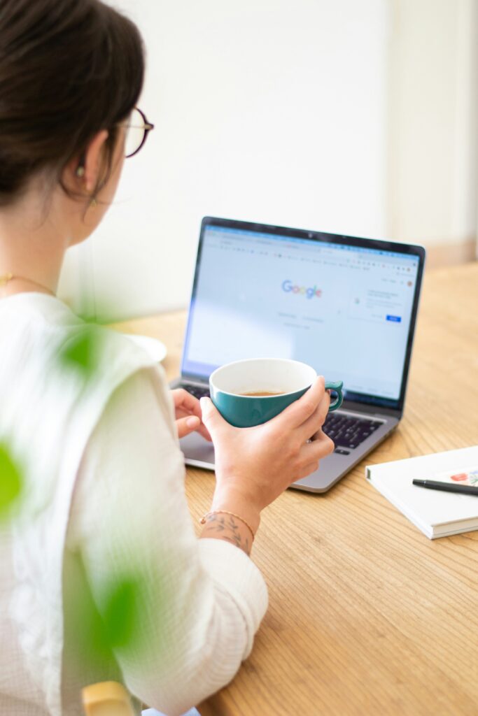 Woman with a coffee in her hand and working from her laptop